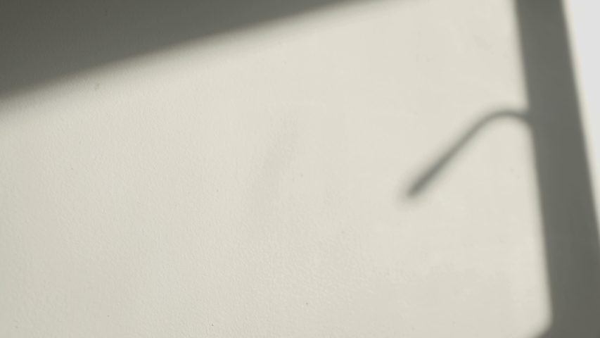 Shadows of a closing window shutter on the white wall of a room Royalty-Free Stock Footage #1030077995