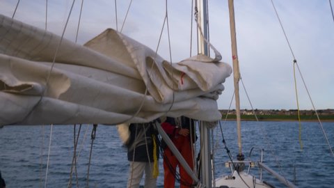 Sail being hoisted on sailing training yacht