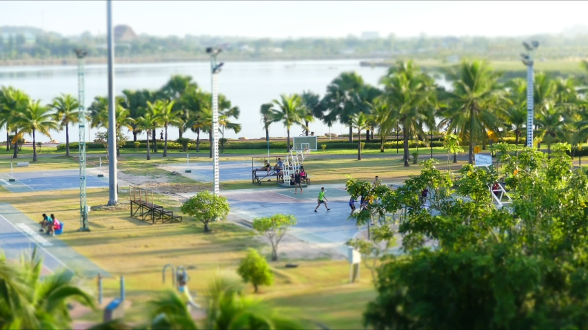 People in the city exercise in the park. Basketball is also played.