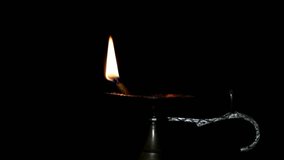 Close up follow focus video of burning oil lamp with Black background,Oil Lamp in Beautiful candlestick. Spiritual, Mystical and Religious Traditions of India. Beautiful bright festive lights