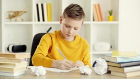 schoolboy drawing on paper, smiling and showing thumb up at home