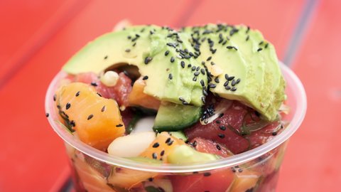 Healthy meal poke sushi bowl being picked with chopsticks