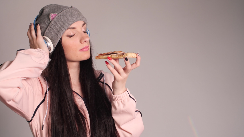 Young caucasian woman eating piece of pizza.