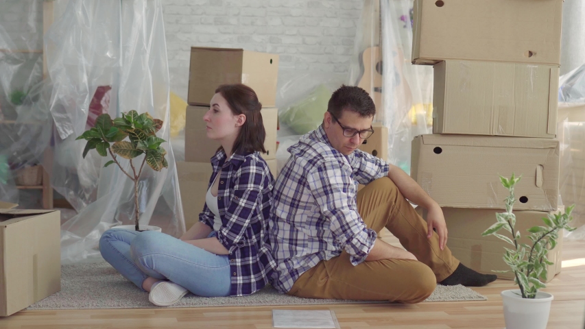 Worried couple middle-aged man and woman sitting in the middle of boxes to move Royalty-Free Stock Footage #1030117043