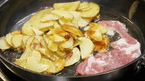 Chef puts the pieces of meat in the pan, where the potatoes are fried in oil, slow motion in close-up - Powered by Shutterstock - Get 15% off with code: PIKWIZARD15