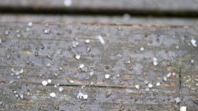 Clip of hail grains on wooden staits, close up