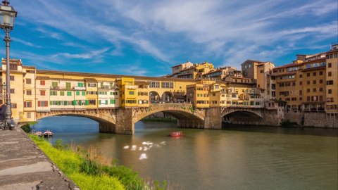 Florence, Tuscany, Italy. Time lapse of The Ponte Vecchio ("Old Bridge") is a medieval stone closed-spandrel segmental arch bridge over the Arno River. Zoom effect. Motion-blur effect