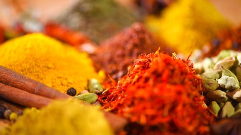 Spices and Herbs. Various Indian backdrop of Spice and herb rotate background. Assortment of Seasonings, Dry colorful condiments on wooden table. Cooking ingredients, flavor. 4K UHD