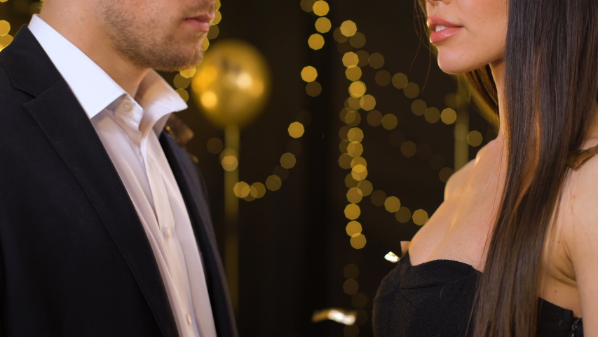 Excited young woman looking at gold ring presented by man, marriage proposal