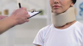 Doctor giving prescription to smiling woman in foam cervical collar, insurance - Powered by Shutterstock - Get 15% off with code: PIKWIZARD15