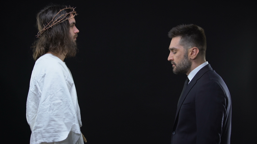 Male businessman kneeling down front of Jesus praising God, asking forgiveness