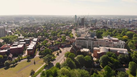 Aerial footage of the Leeds town of Headingley, the footage shows the famous Leeds University campus and the town centre in the background with roads and traffic, taken on a beautiful sunny day.