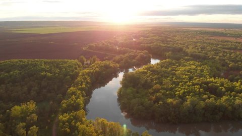 River Aerial Landscape Cinematic Drone Footage at sunset time. Flying above Dniestr river in Ukraine or Moldova with forests and fields around