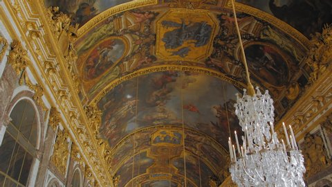 Versailles, PARIS, FRANCE- August 2018: Luxurious frescoes on the ceiling and interior. a lot of tourists in the main hall of the royal palace. Visitors take pictures of the landmark.
