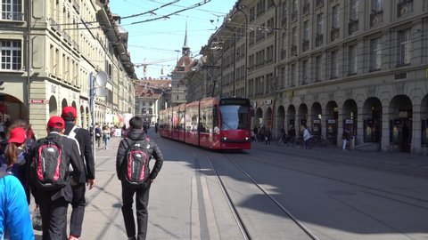 Bern, Switzerland - March 30, 2019: Public transport in Switzerland, City Trams in red color commute in the old medieval city of Bern. It is the safest and fastest way to travel within city.