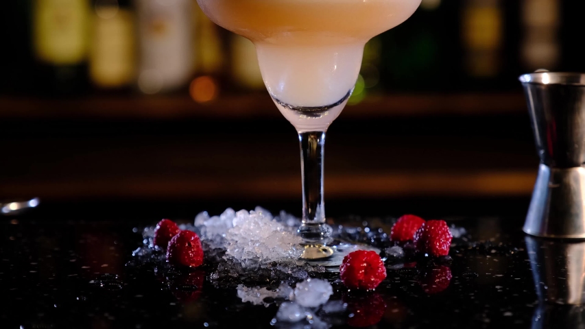 Clover Club is a classic cocktail that contains gin, raspberry syrup, lemon juice and a few drops of egg white in the bar, camera goes up with the possibility of mounting Royalty-Free Stock Footage #1030201802