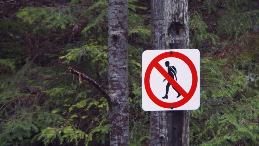 Slow zoom in, showing a sign forbidding hiking outside the trails of Zakopane mountain range in Poland.