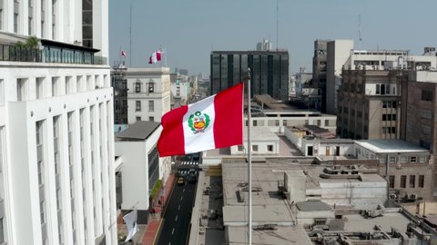 Peruvian flag waving against buildings in the historic center of Lima, the capital of Peru. Patriotism and nationalism concepts.