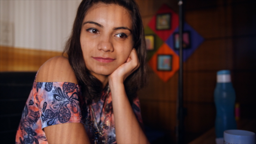 Beautiful Indian girl sitting idle and thinking in a dark room.