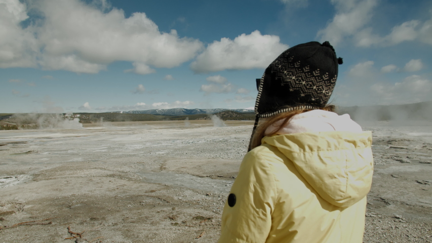 Caucasian female enjoying the view of boiling geysers in Yellowstone. 4K UHD 60 FPS SLOW MOTION