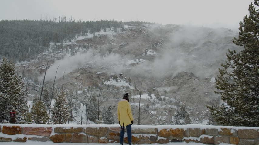 Caucasian female enjoying the view of boiling geysers in Yellowstone. 4K UHD 60 FPS SLOW MOTION