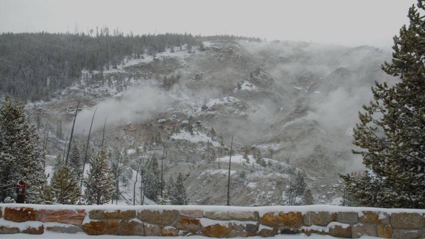 FIXED View of a mountain with geysers during heavy snowfall in winter. 4K UHD 60 FPS SLOW MOTION