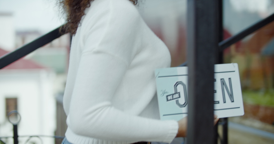 Beautiful African American black female placing an open sign on the entrance door of her small cafe. Small business concept. 4K UHD  SLOW MOTION