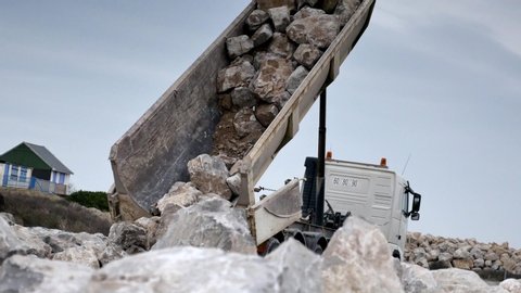 dump truck emptying his trailer of rocks on the site