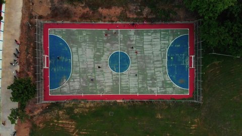 Outdoor futsal, soccer court with players at both team in Thai public school
