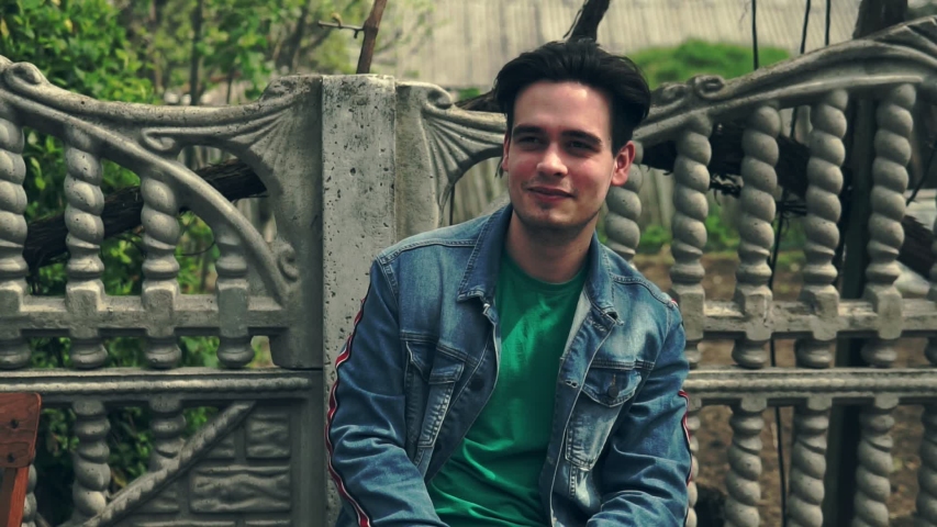 A young guy looks into the camera and tells something emotionally.