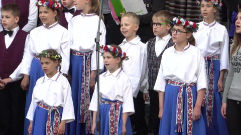Dobele, Latvia - May 24 of 2019. Latvian traditional culture. Choir on the stage in action. Children and young chorus performance in close-up.