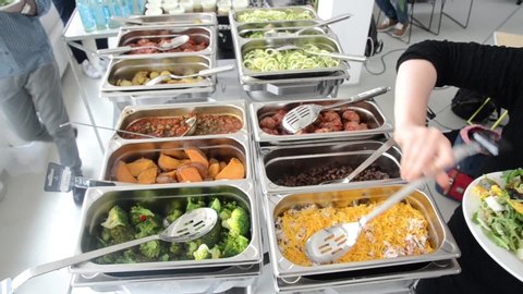Hot food served on table in restaurant. People serving themselves. Vegetables on a self-service catered buffet. Delicious, healthy and tasty vegetarian meals prepared for lunch. Swedish table buffet