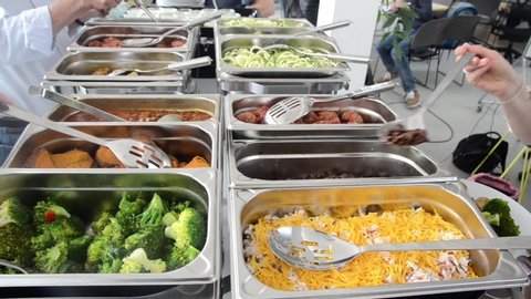 Hot food served on table in restaurant. People serving themselves. Vegetables on a self-service catered buffet. Delicious, healthy and tasty vegetarian meals prepared for lunch. Swedish table buffet
