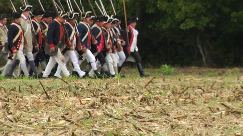 VIRGINIA - OCTOBER 2016 - Reenactment, large-scale, epic American Revolutionary War anniversary recreation -- Army Soldiers in formation marching as on parade with Muskets, flags & drums.