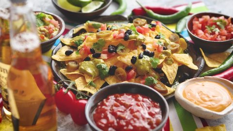 Mexican corn nacho spicy chips served with melted cheese, peppers, tomatoes, beer and side salsas.