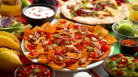 An overhead photo of an assortment of many different Mexican foods, including tacos, guacamole, nachos with grilled chicken, tortillas, salsas and others - Powered by Shutterstock - Get 15% off with code: PIKWIZARD15