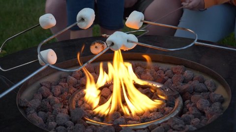 Roasting marshmallows on the backyard fire pit - slow motion