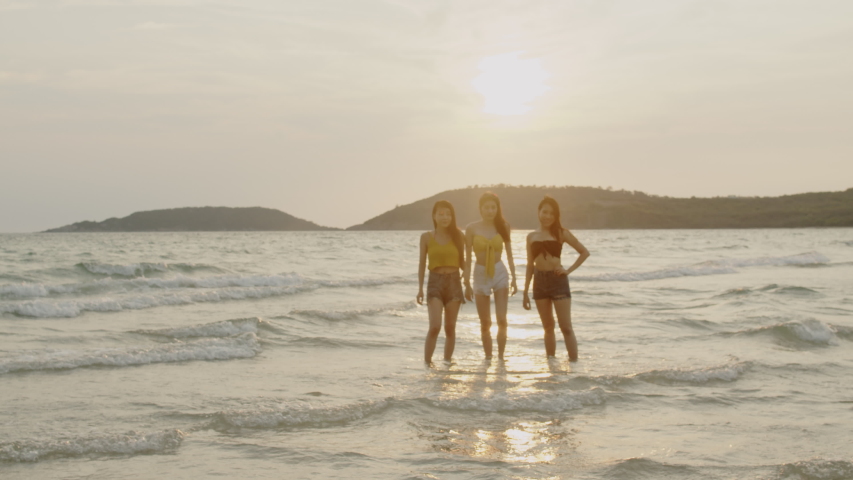 Group of Asian young women running on beach, friends happy relax having fun playing on beach near sea when sunset in evening. Lifestyle friends travel holiday vacation summer concept. 4k Slow motion. | Shutterstock HD Video #1030323317