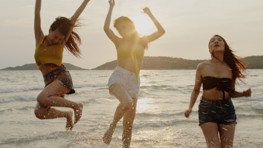 Group of Asian young women running on beach, friends happy relax having fun playing on beach near sea when sunset in evening. Lifestyle friends travel holiday vacation summer concept. 4k Slow motion. Royalty-Free Stock Footage #1030323317