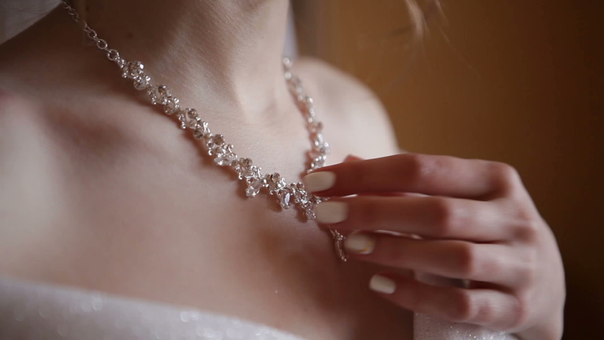 The bride hand straightens the necklace.
Bride dresses a riviere. Girl's wedding morning. Royalty-Free Stock Footage #1030329812