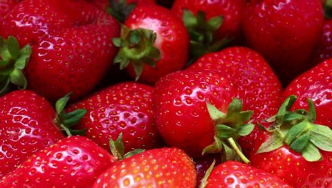 Many strawberries rotating close up