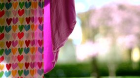 Close Up colorful Clothes with hearts Drying In The Little Wind On A Clothesline Outside In The Sun