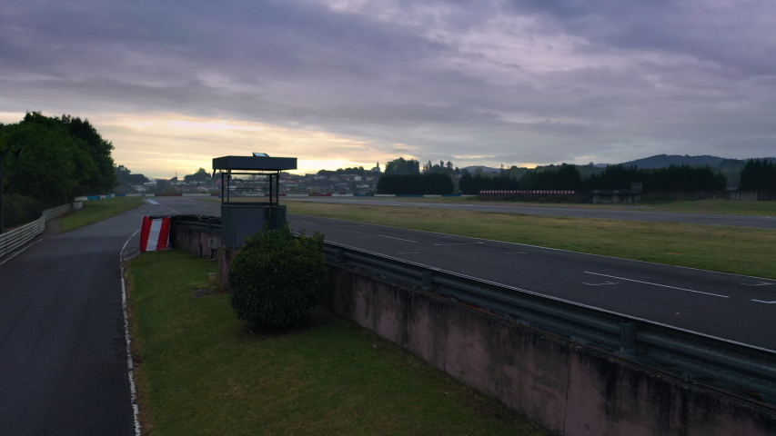 Empty race track crane shot, with a beautiful purple sky ant sunrise. Shot by drone at grid line.