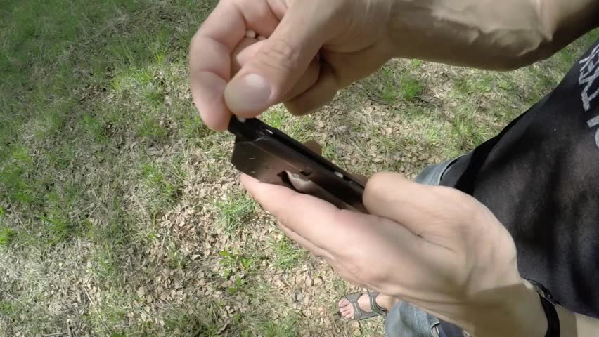 Man charging a handgun plastic balls for airsoft outdoor 