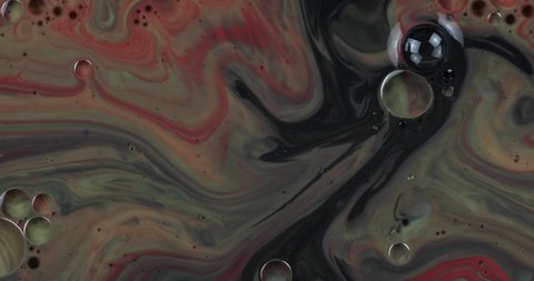 Abstract psychedelic background. Slow movement of ink in a multicolored liquid. Colorful paint drops mixing in water. Ink swirling underwater. River of liquid, movement of colorful paint.