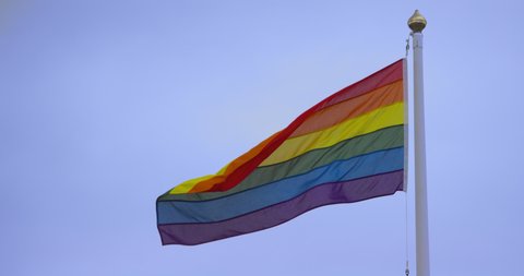 Rainbow flag gay pride LGBTQ blowing in the wind 
