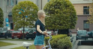 Young modern woman riding bicycle in city. 4K slow motion video footage 60 fps