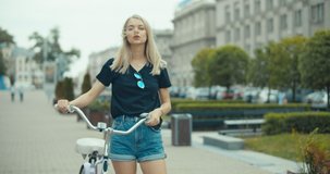 Young modern woman riding bicycle in city. 4K slow motion video footage 60 fps