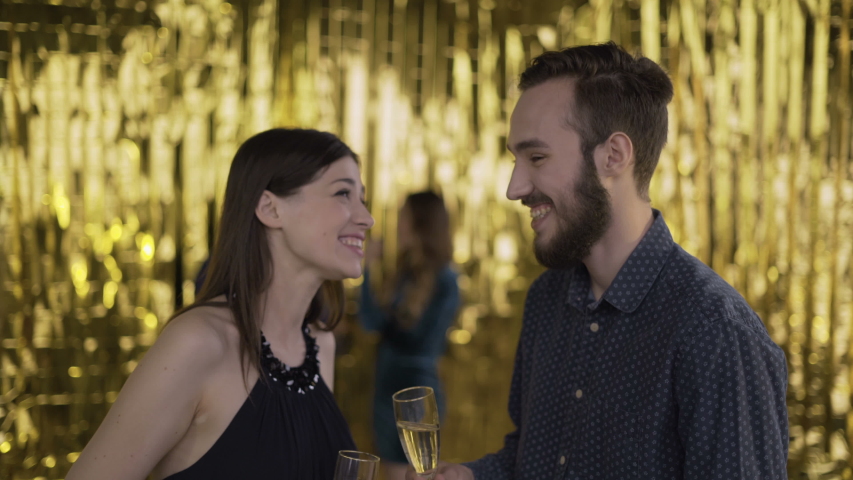 Meeting at a party. man and woman meet at the disco. close-up on a gold background. 4K | Shutterstock HD Video #1030372448