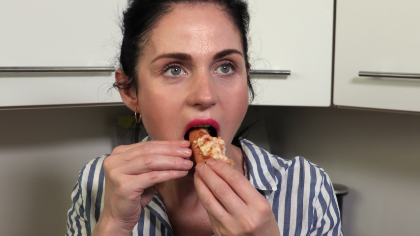 Woman with piece of Pizza in kitchen Stock Footage Video